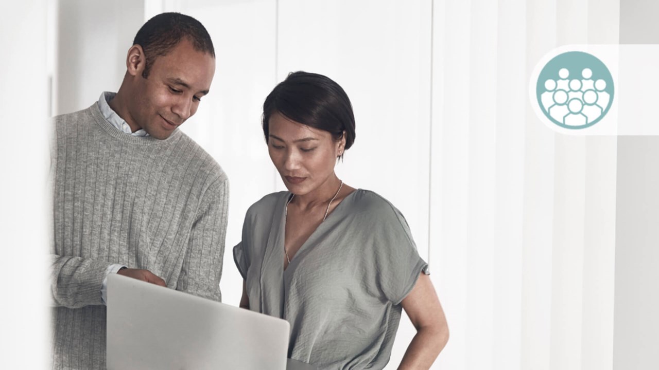 A female and a male discussing over a laptop